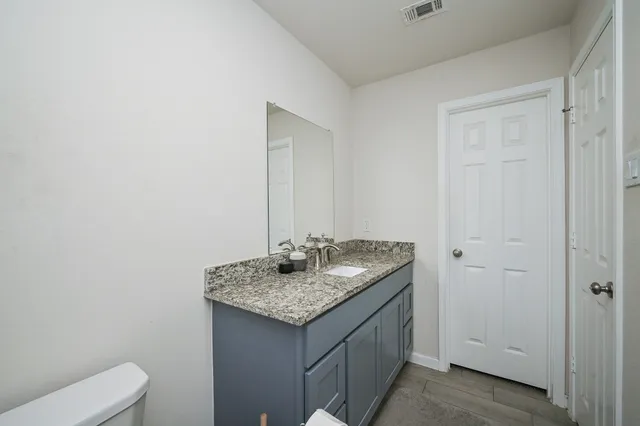 a bathroom with a granite countertop sink and a mirror