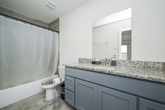 a bathroom with a granite countertop sink and a mirror