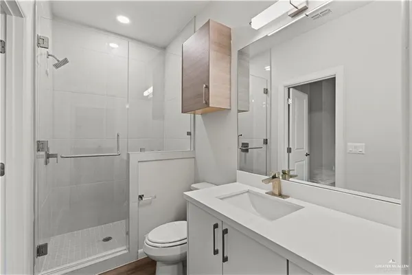 a bathroom with a sink toilet a mirror and shower