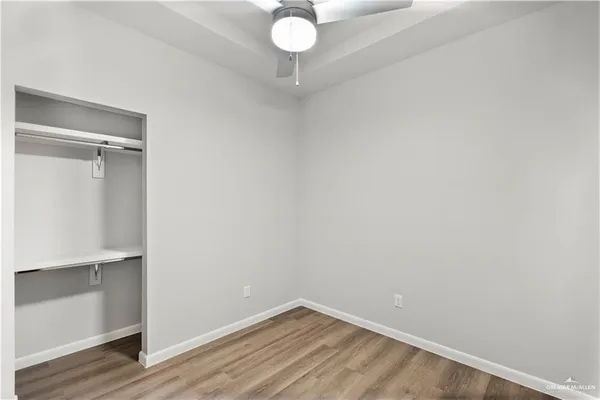 a view of a room with wooden floor and fan
