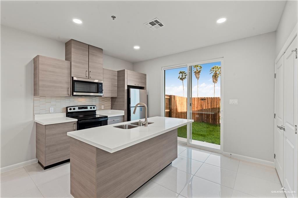 3512 Vanessa Lane, Unit 3 Weslaco, TX 78599 - Photo 4 of 20 a kitchen with a sink a counter top space appliances and cabinets