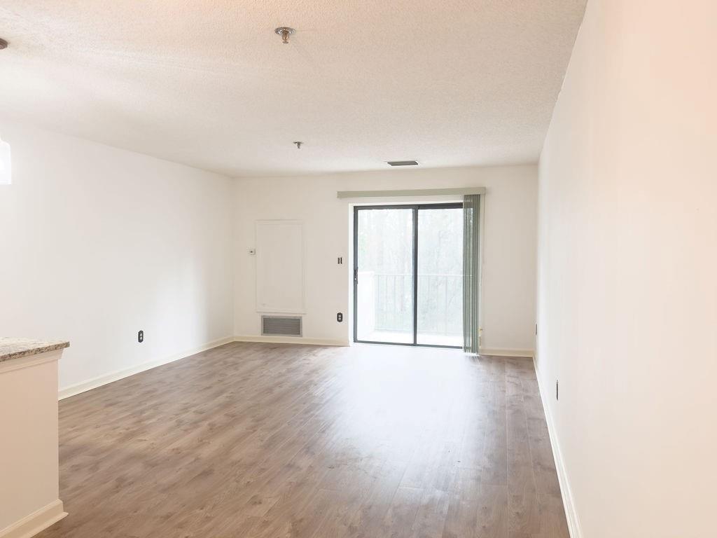 300 Johnson Ferry Road, Unit A305 Atlanta, GA 30328 - Photo 13 of 27 a view of an empty room with wooden floor and windows