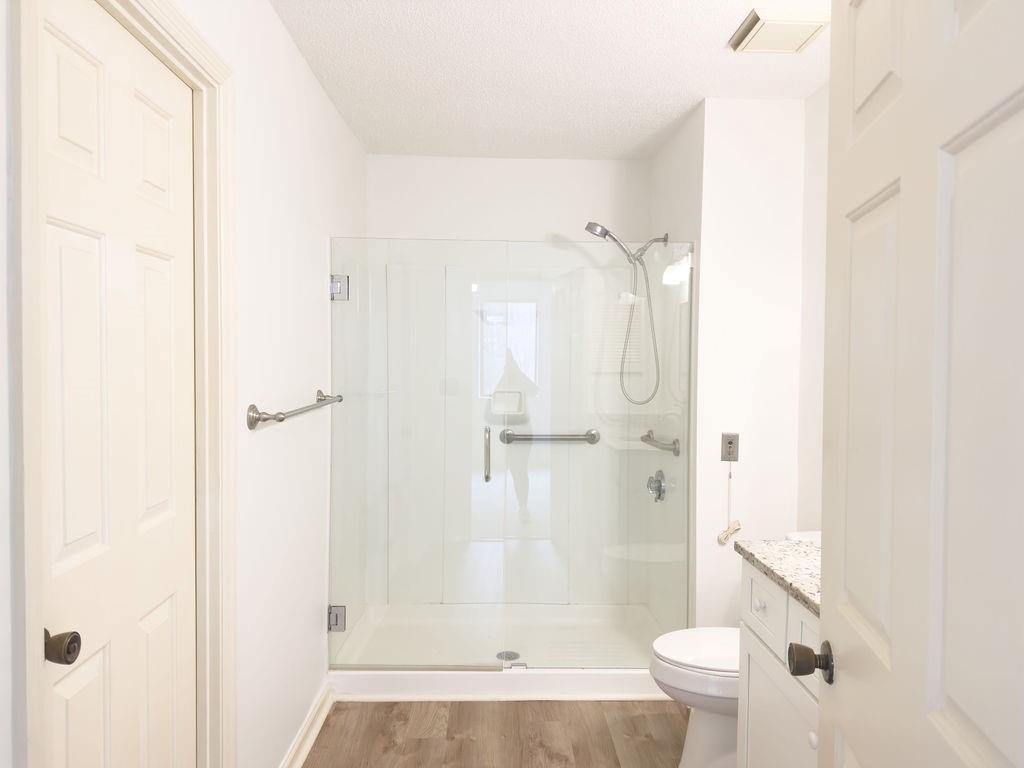 300 Johnson Ferry Road, Unit A305 Atlanta, GA 30328 - Photo 6 of 27 a bathroom with a granite countertop shower a toilet and a shower