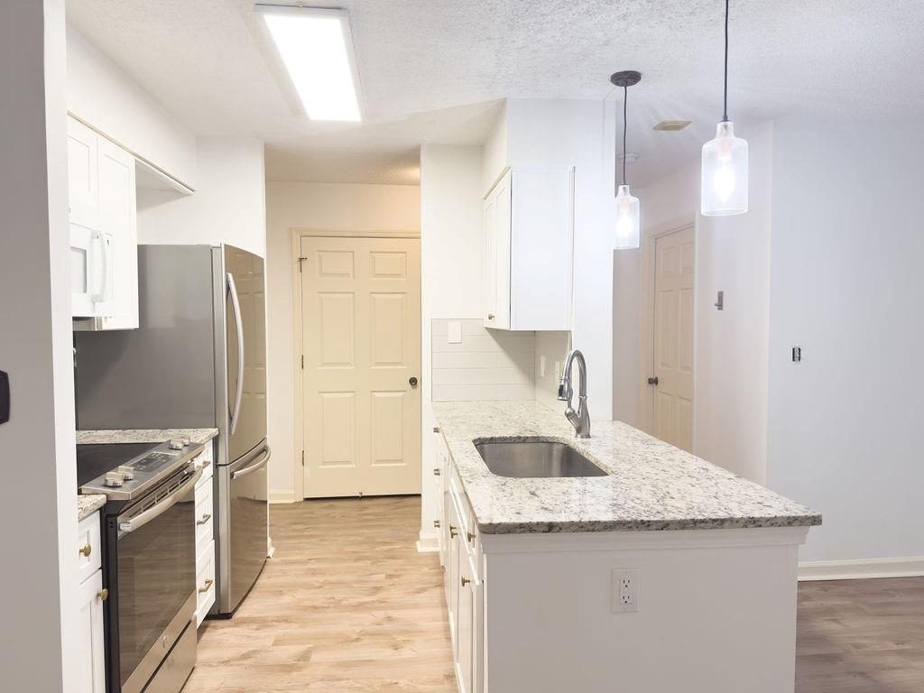 300 Johnson Ferry Road, Unit A305 Atlanta, GA 30328 - Photo 10 of 27 a kitchen with granite countertop a refrigerator a sink and a stove