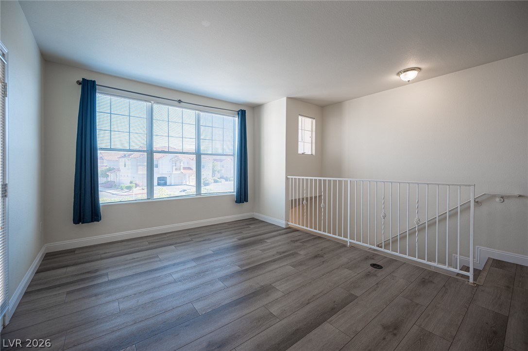 8555 West Russell Road, Unit 2062 Las Vegas, NV 89113 - Photo 8 of 35 A well-lit upper level space with wood flooring and a view of the neighborhood through ample windows.