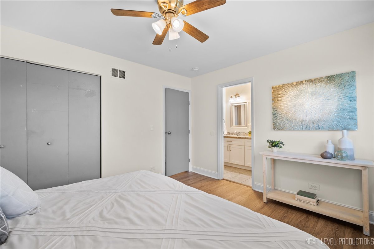 5628 Crestwood Road Matteson, IL 60443 - Photo 13 of 30 a bedroom with a bed and a chandelier