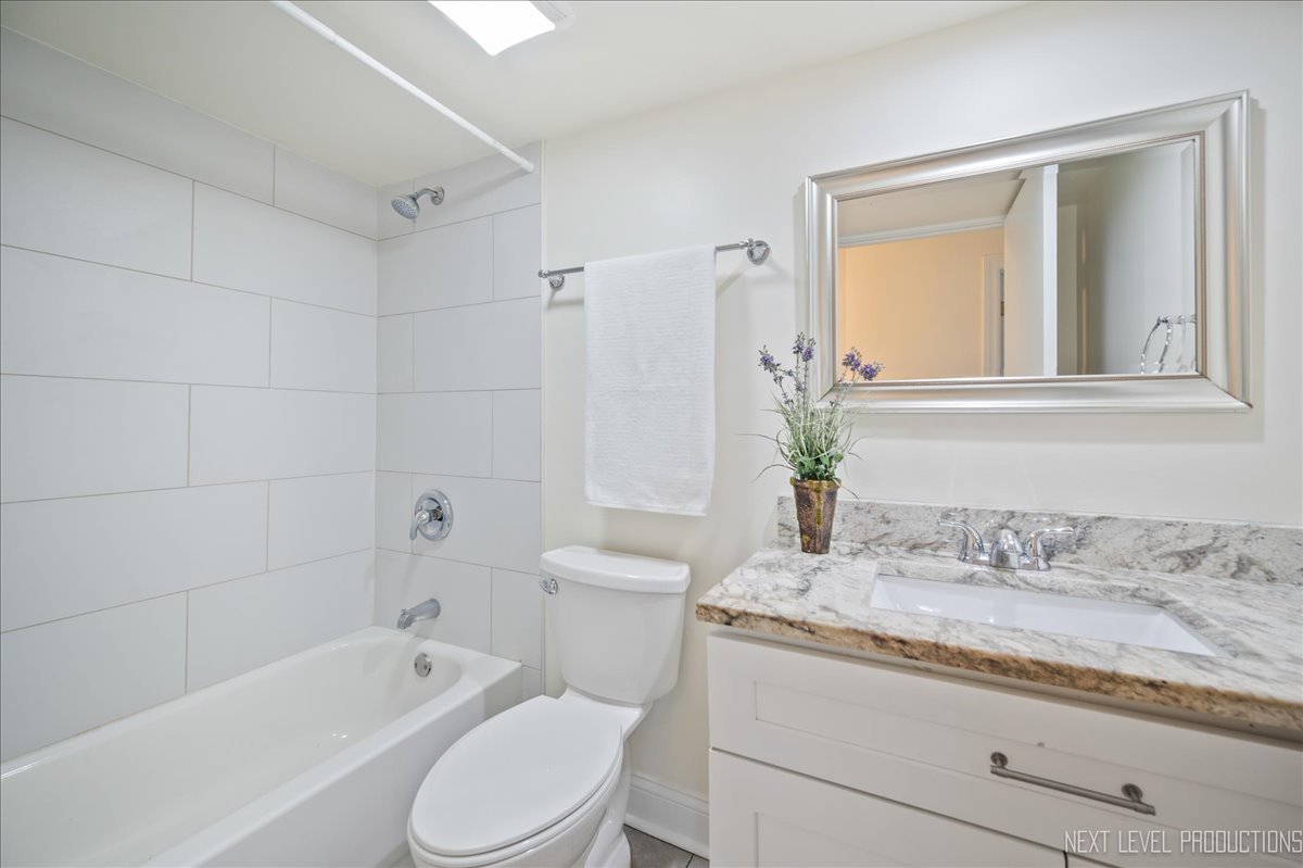 5628 Crestwood Road Matteson, IL 60443 - Photo 25 of 30 a bathroom with a granite countertop toilet a sink and bathtub