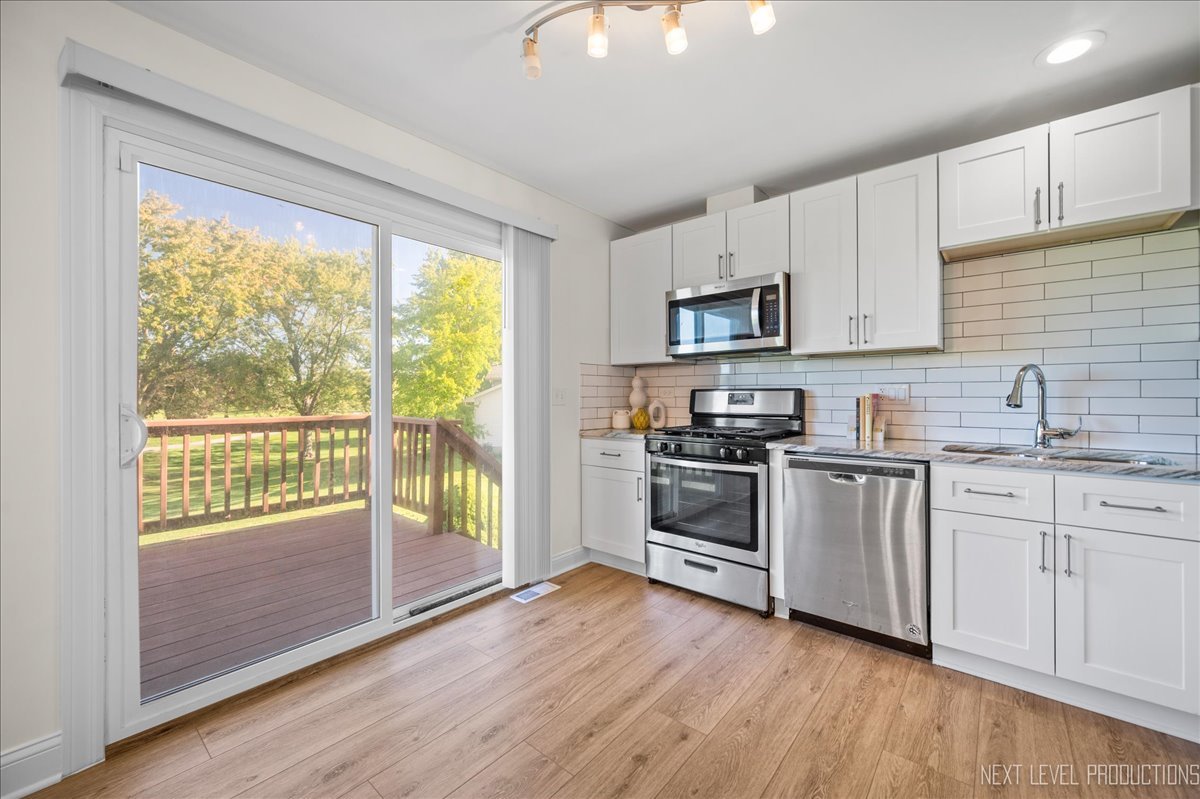 5628 Crestwood Road Matteson, IL 60443 - Photo 4 of 30 a kitchen with granite countertop a stove a sink and a microwave