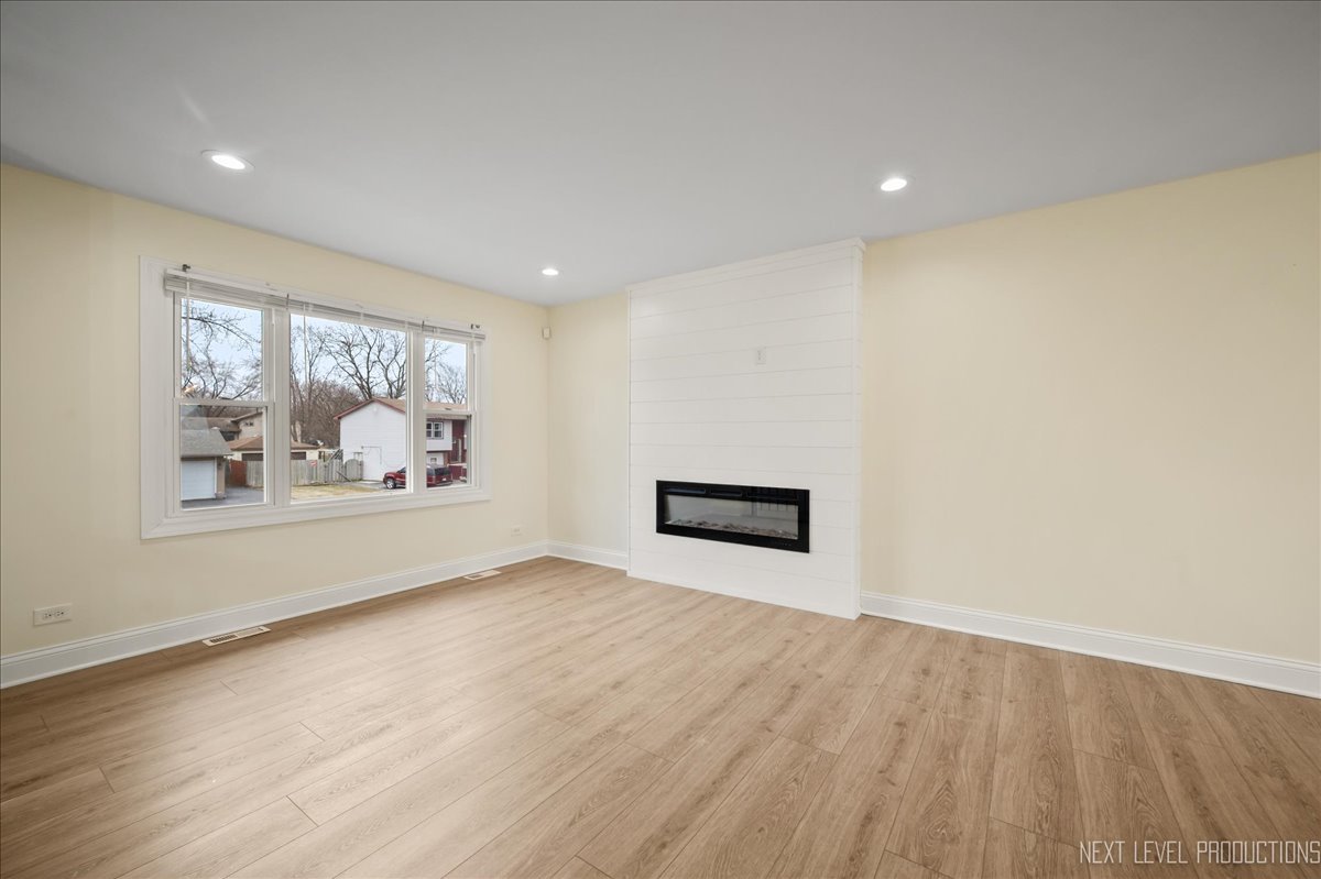 5628 Crestwood Road Matteson, IL 60443 - Photo 8 of 30 a view of an empty room with wooden floor and a window