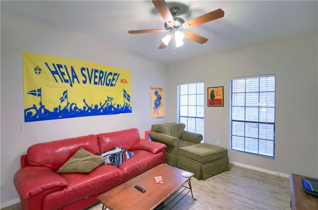 2801 Rio Grande Street, Unit 104 Austin, TX 78705 - Photo 2 of 9 a blue couch sitting in a living room with a book shelf