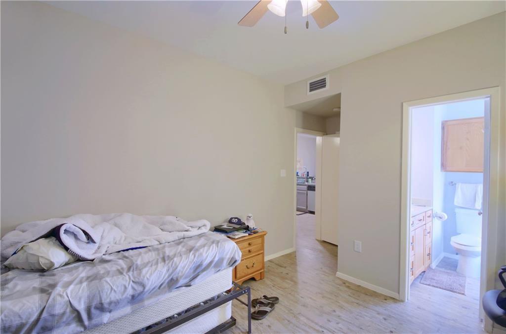 2801 Rio Grande Street, Unit 104 Austin, TX 78705 - Photo 3 of 9 a bedroom with a bed and a chandelier