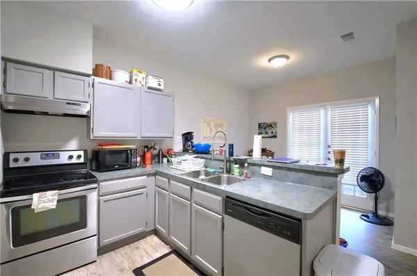 a kitchen with a sink appliances and cabinets
