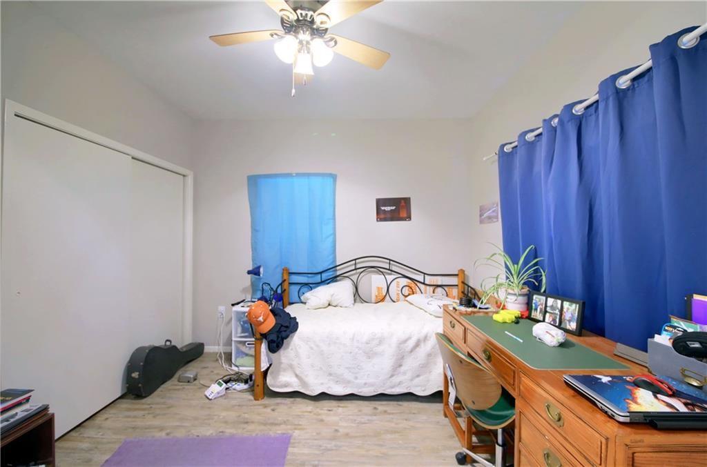 2801 Rio Grande Street, Unit 104 Austin, TX 78705 - Photo 7 of 9 a bedroom with bed and a chandelier