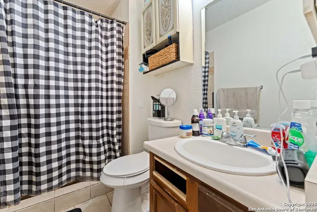 a bathroom with a sink toilet vanity and shower