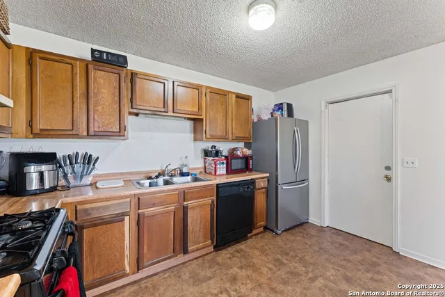 a kitchen with stainless steel appliances granite countertop a stove a sink dishwasher and a refrigerator