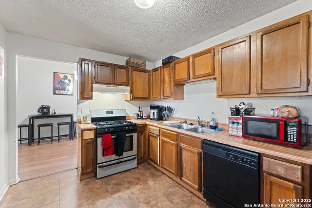 a kitchen with stainless steel appliances granite countertop a stove sink and cabinets