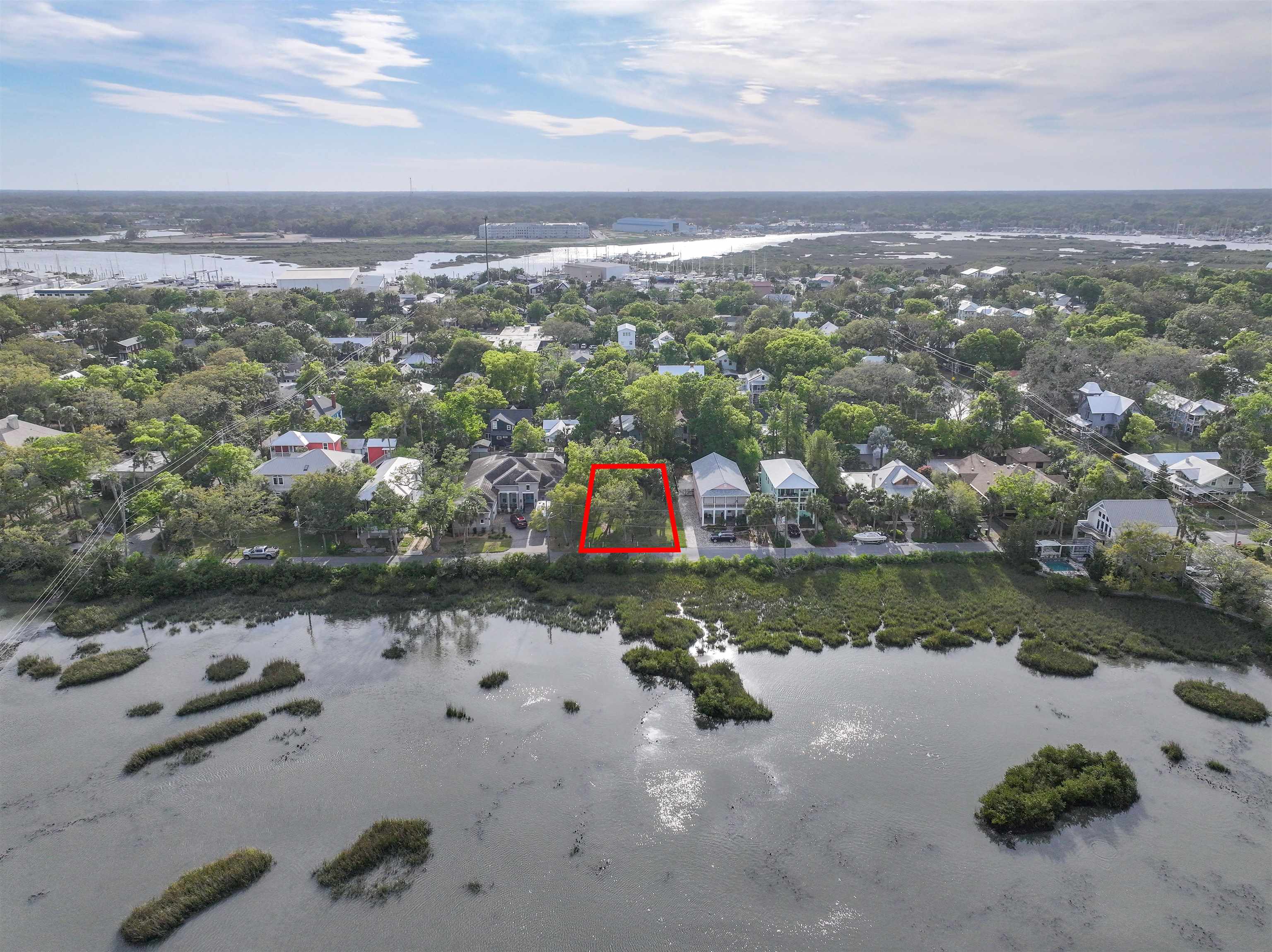 an aerial view of a house with a yard and lake view in back