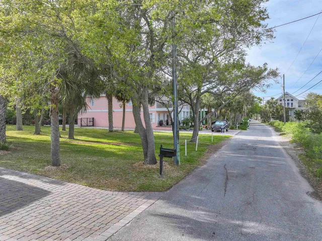 a front view of a house with garden and trees