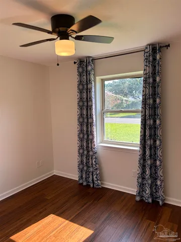 a view of a big room with wooden floor closet and chandelier fan