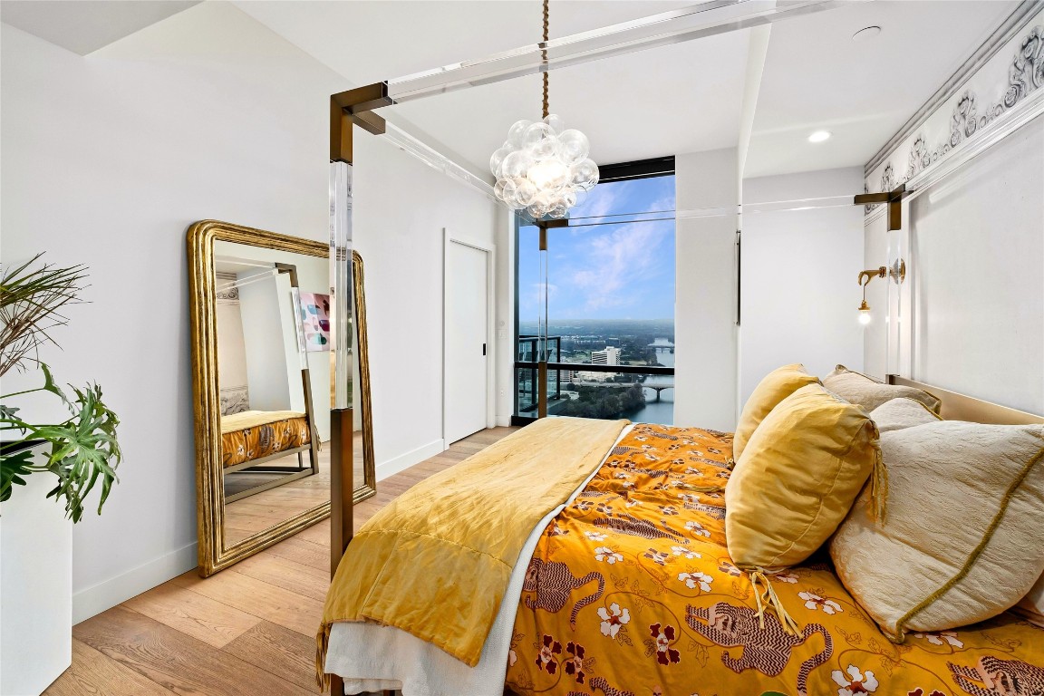 70 Rainey Street, Unit 2702 Austin, TX 78701 - Photo 13 of 40 a bedroom with a bed and a wooden floor