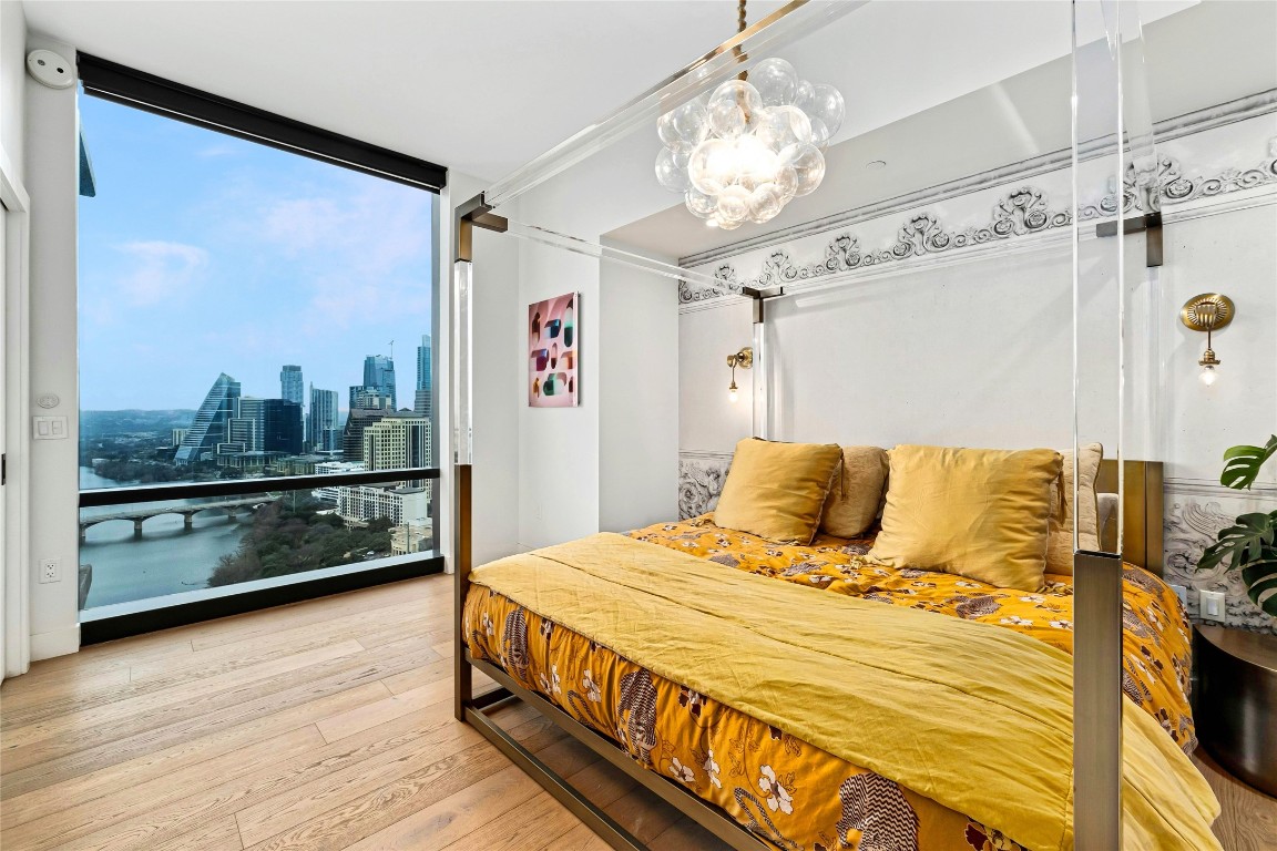70 Rainey Street, Unit 2702 Austin, TX 78701 - Photo 14 of 40 a bedroom with a bed and wooden floor