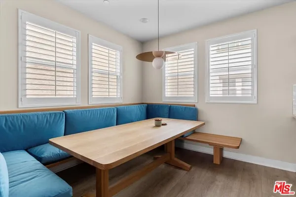 a kitchen with stainless steel appliances granite countertop a refrigerator a sink a stove a dining table and chairs