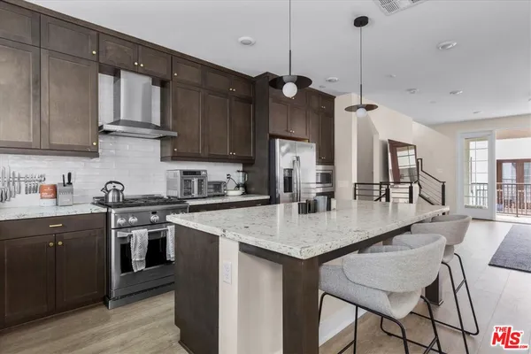 a view of kitchen island a sink wooden floor and a center island