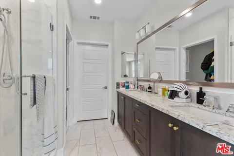 a bedroom with a bed a chair and next to a window