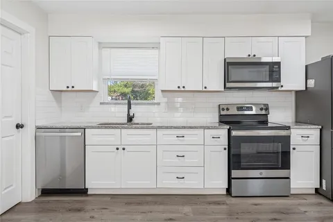 a kitchen with white cabinets and stainless steel appliances