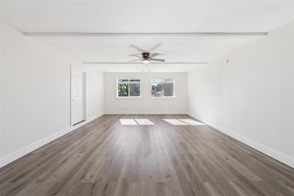 2126 Travis Drive Carrollton, TX 75006 - Photo 11 of 23 an empty room with wooden floor and windows