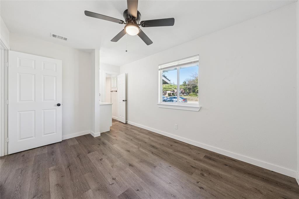 2126 Travis Drive Carrollton, TX 75006 - Photo 15 of 23 an empty room with wooden floor ceiling fan and windows