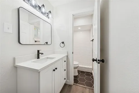 a bathroom with a sink mirror toilet and vanity