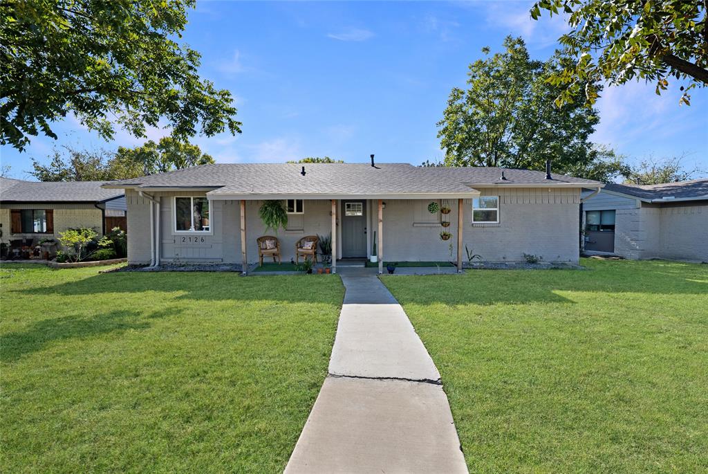 2126 Travis Drive Carrollton, TX 75006 - Photo 2 of 23 a front view of a house with a garden