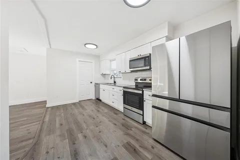 a kitchen with stainless steel appliances a refrigerator sink and microwave