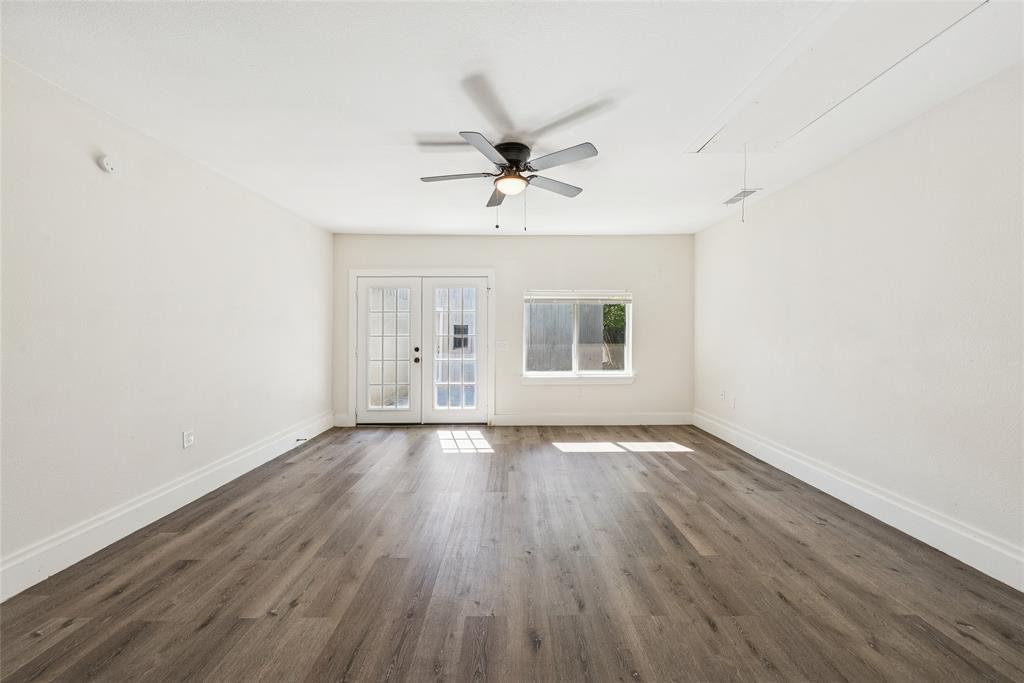 2126 Travis Drive Carrollton, TX 75006 - Photo 9 of 23 an empty room with wooden floor ceiling fan and windows