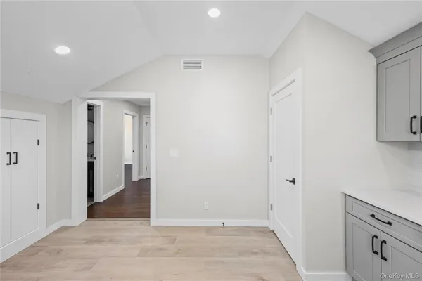 a view of an empty room with wooden floor