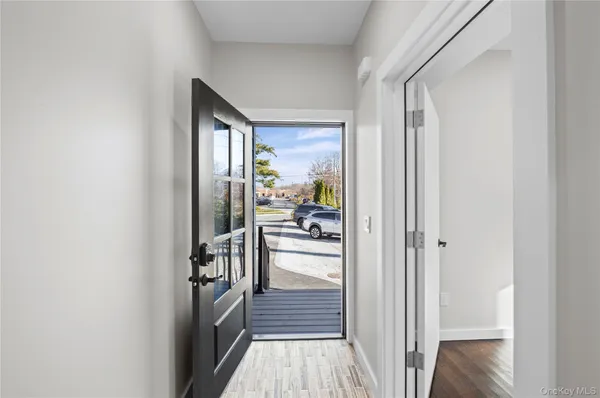 a view of a hallway with wooden floor and a living room