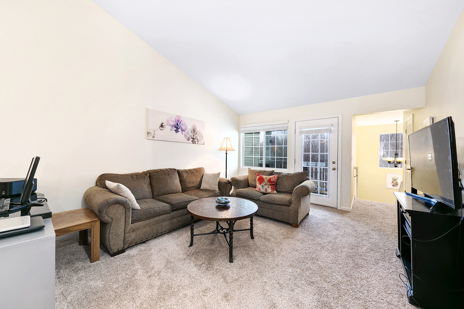 1488 McClure Road, Unit 1488 Aurora, IL 60505 - Photo 10 of 19 a living room with furniture a flat screen tv and a refrigerator