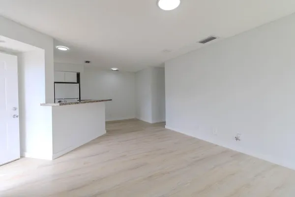 a view of a kitchen with a sink and refrigerator