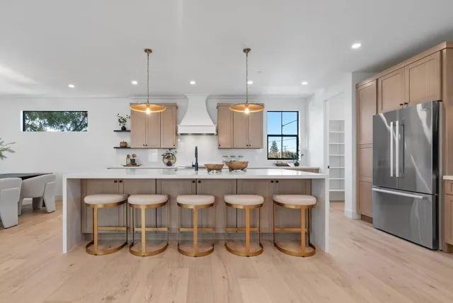 a large kitchen with kitchen island a sink a stove a center island and cabinets