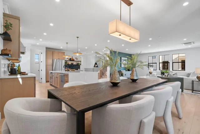 a large kitchen with kitchen island a large counter top space a sink a stove and a chandelier