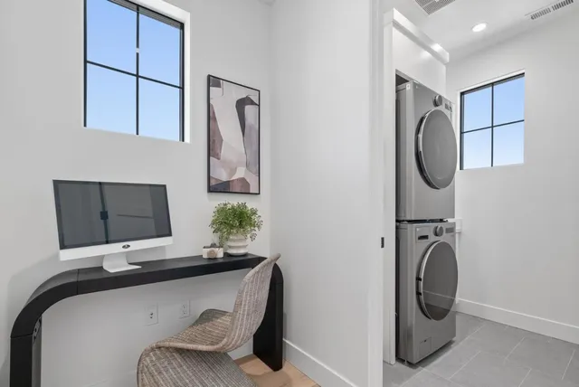 a bedroom with bed a painting on wall and a potted plant
