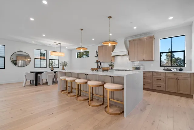 a large kitchen with kitchen island a sink table and chairs