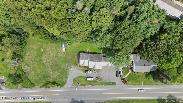 an aerial view of a house with a yard and lake view