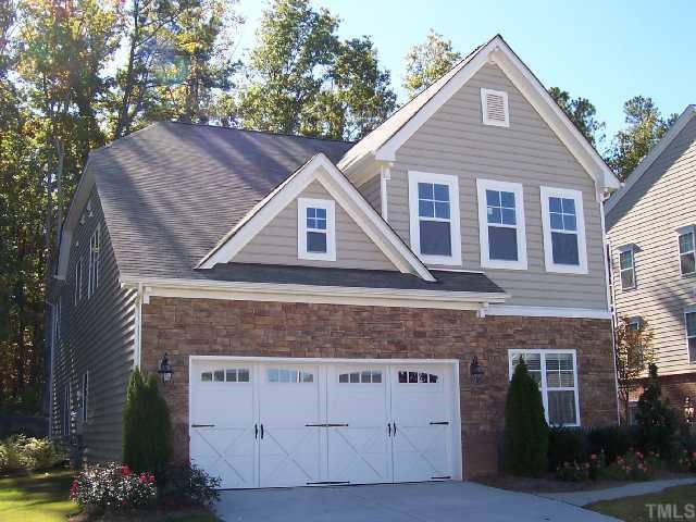 a front view of a house with a tree