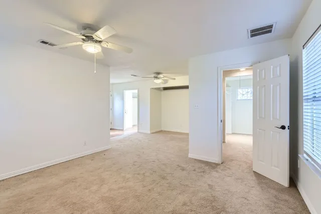 an empty room with fan and entrance