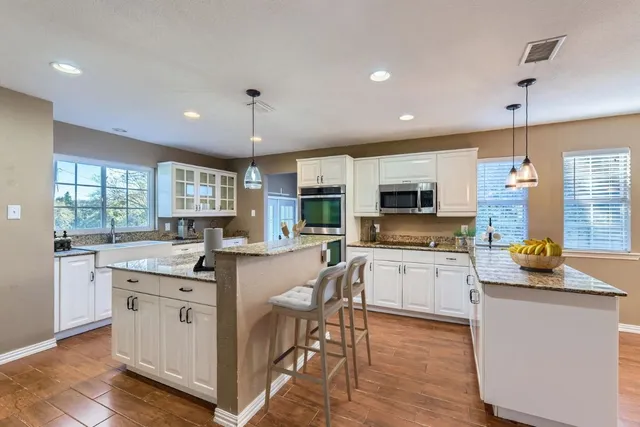 a kitchen with a stove top oven a sink a dining table and chairs