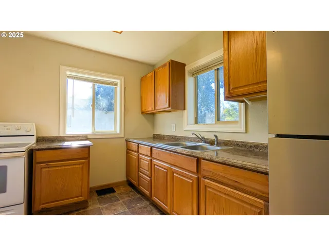 a kitchen with a sink cabinets appliances and a window