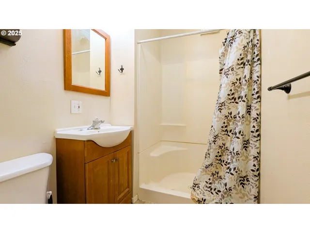 a open hall with a hardwood floor and a cabinet