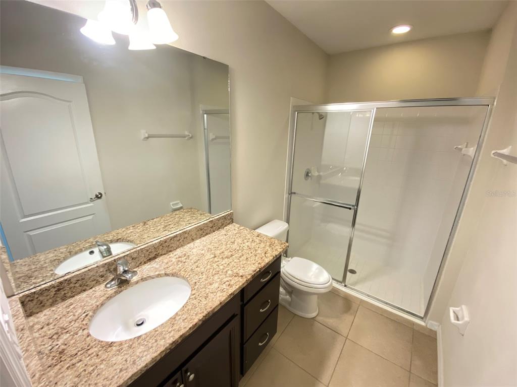 600 Northern Way, Unit 1001 Winter Springs, FL 32708 - Photo 4 of 37 a bathroom with a granite countertop sink a mirror and a toilet